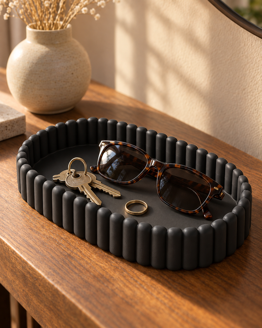 Ripple Catch-All Tray in Matte Black holding keys, sunglasses and a ring on a wooden entryway console