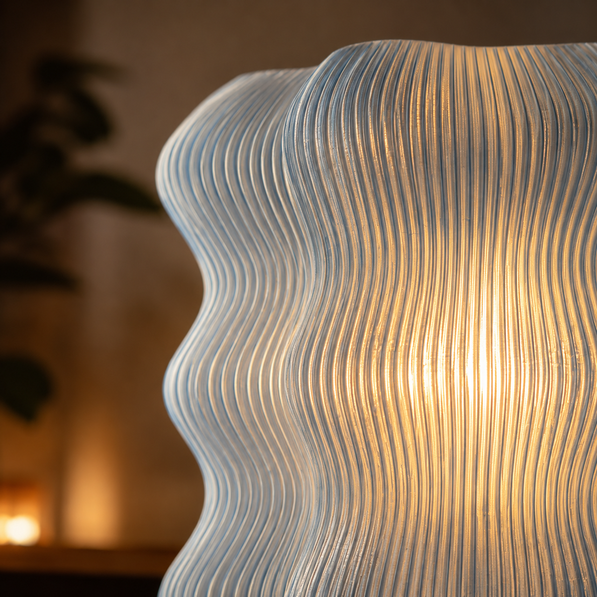 Close-up of the Wave Table Lamp's ribbed wavy texture glowing warm