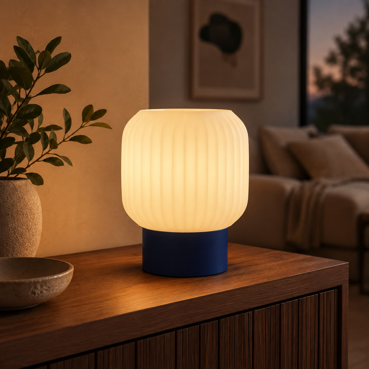 Drum Ribbed Table Lamp in Deep Indigo Blue glowing on a wooden console table