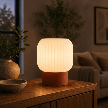 Drum Ribbed Table Lamp in Burnt Rust glowing on a wooden console table
