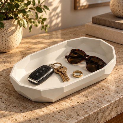 Facet Oval Catch-All Tray in Jade White holding keys, sunglasses and a ring on a travertine entryway console