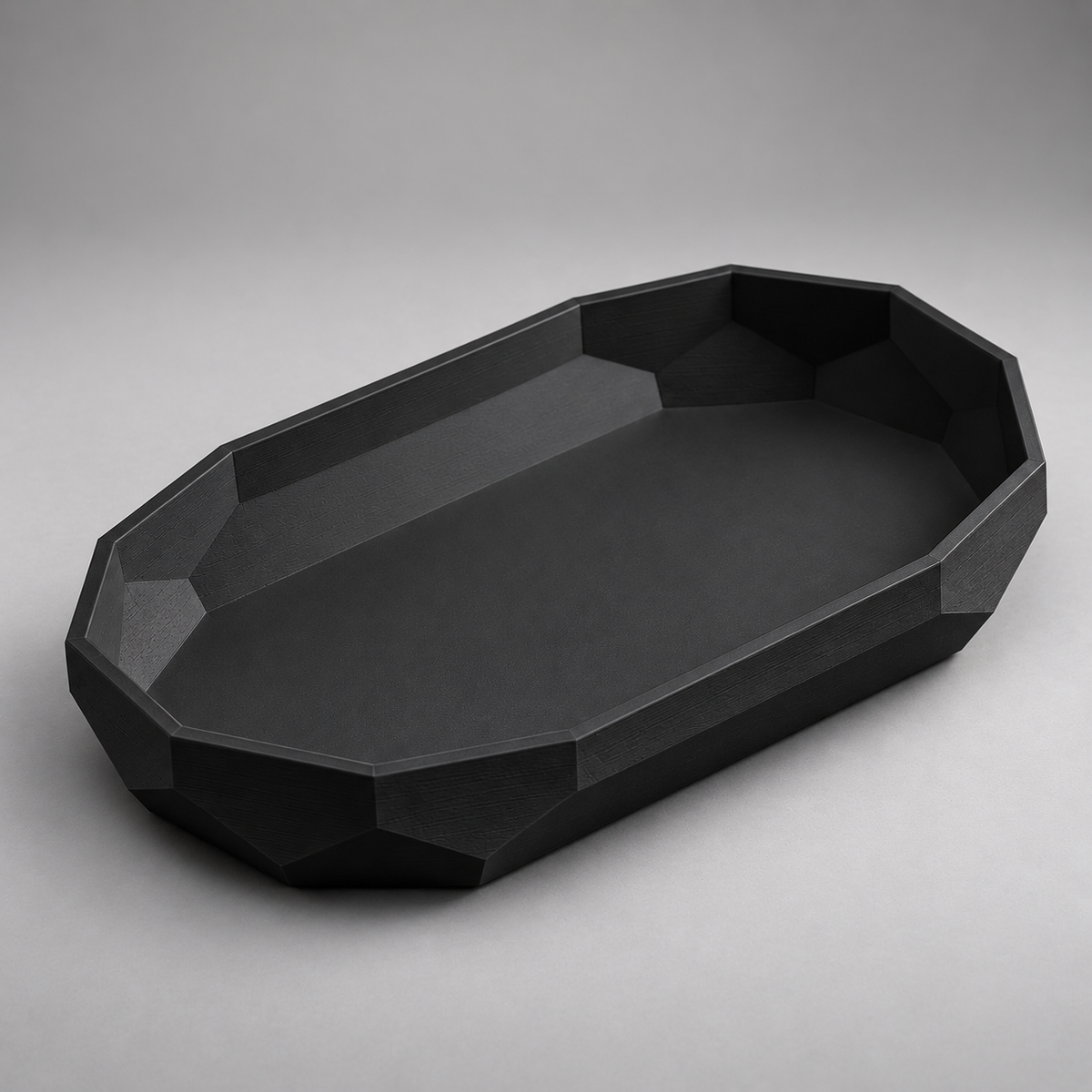 DiyArts Facet Oval Catch-All Tray in Matte Black, faceted geometric wall, studio product shot