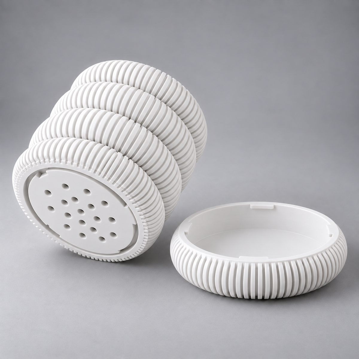 Coin Stack Planter in Jade White shown apart - pot underside with 17 drainage holes and the matching hidden drip tray