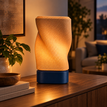 Twist Weave Table Lamp in Deep Indigo Blue glowing on a wooden console table