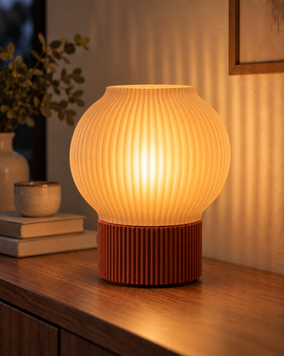 Ripple Table Lamp, Globe shade in Translucent Honey, glowing on a wooden console table
