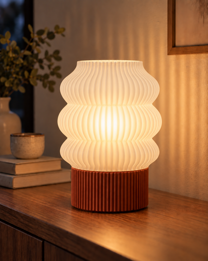 Ripple Table Lamp, Triple Wave shade in Jade White, glowing on a wooden console table