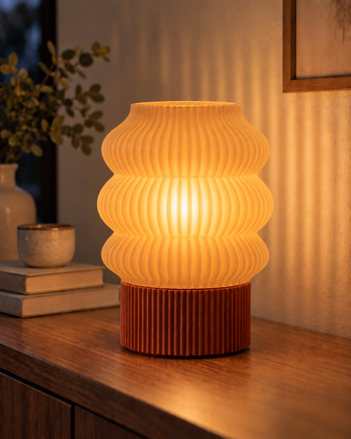 Ripple Table Lamp, Triple Wave shade in Translucent Honey, glowing on a wooden console table