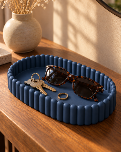 Ripple Catch-All Tray in Deep Indigo Blue holding keys, sunglasses and a ring on a wooden entryway console