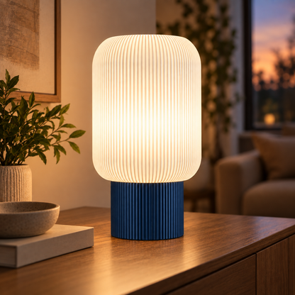 Column Ribbed Table Lamp, Cylinder base in Deep Indigo Blue, glowing on a wooden console table
