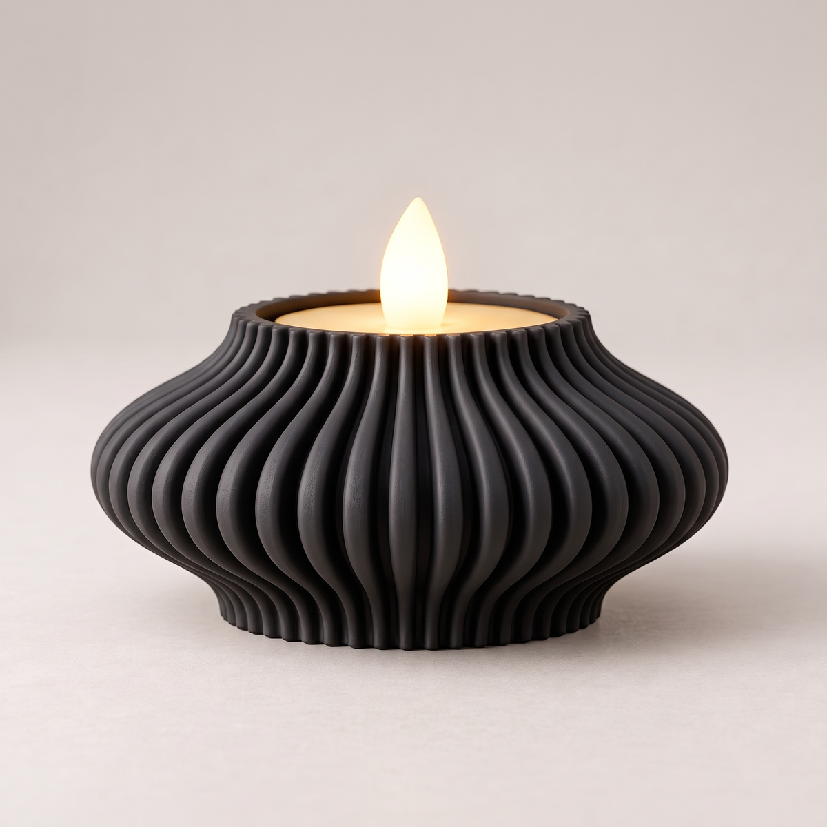 DiyArts Fluted Tealight Candle Holder in Matte Black, sculptural ribbed fins with an LED tealight, studio product shot