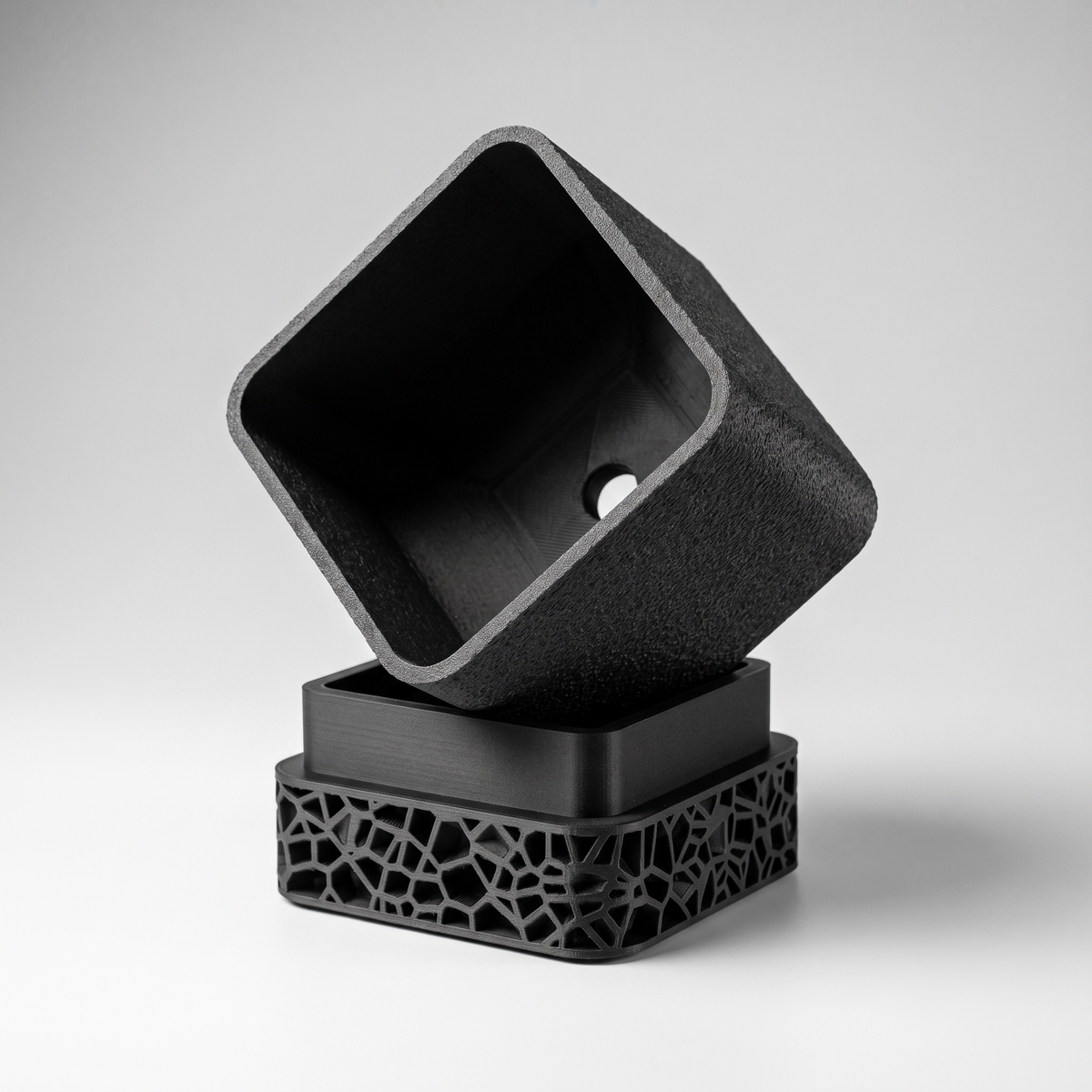 Voronoi Square Planter in Matte Black shown apart - pot with drainage hole and the Voronoi lattice drip tray base