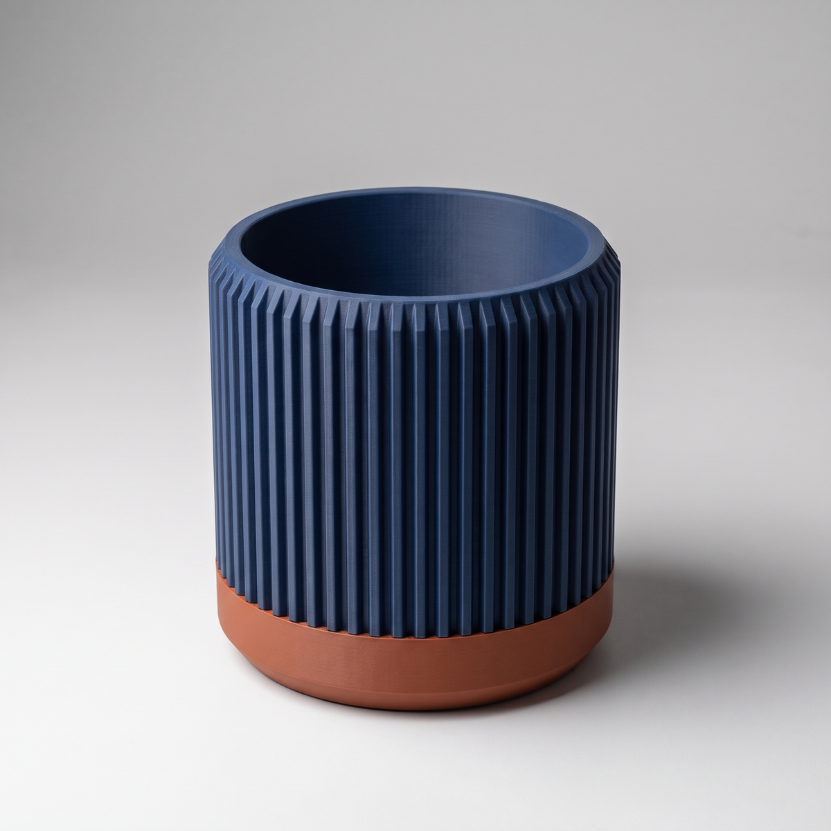 DiyArts Fluted Cylinder Planter with Saucer in Deep Indigo Blue with burnt rust saucer, ribbed 4 inch plant pot, studio product shot