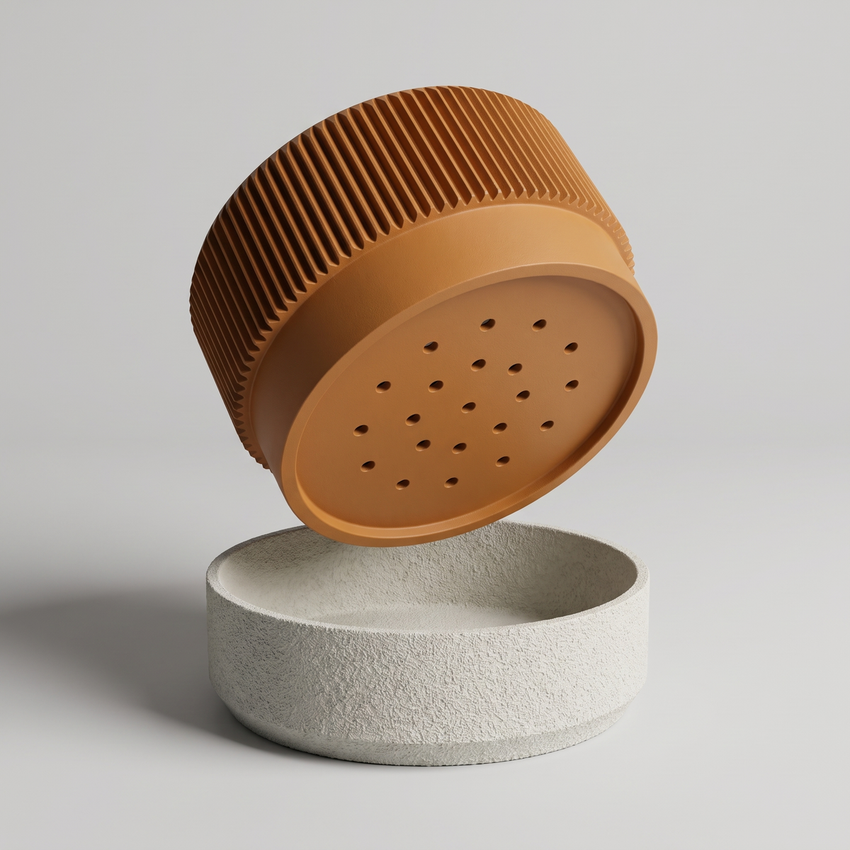 Ribbed Wide Planter in Burnt Rust shown apart - pot underside with nineteen drainage holes above the built-in textured drip tray