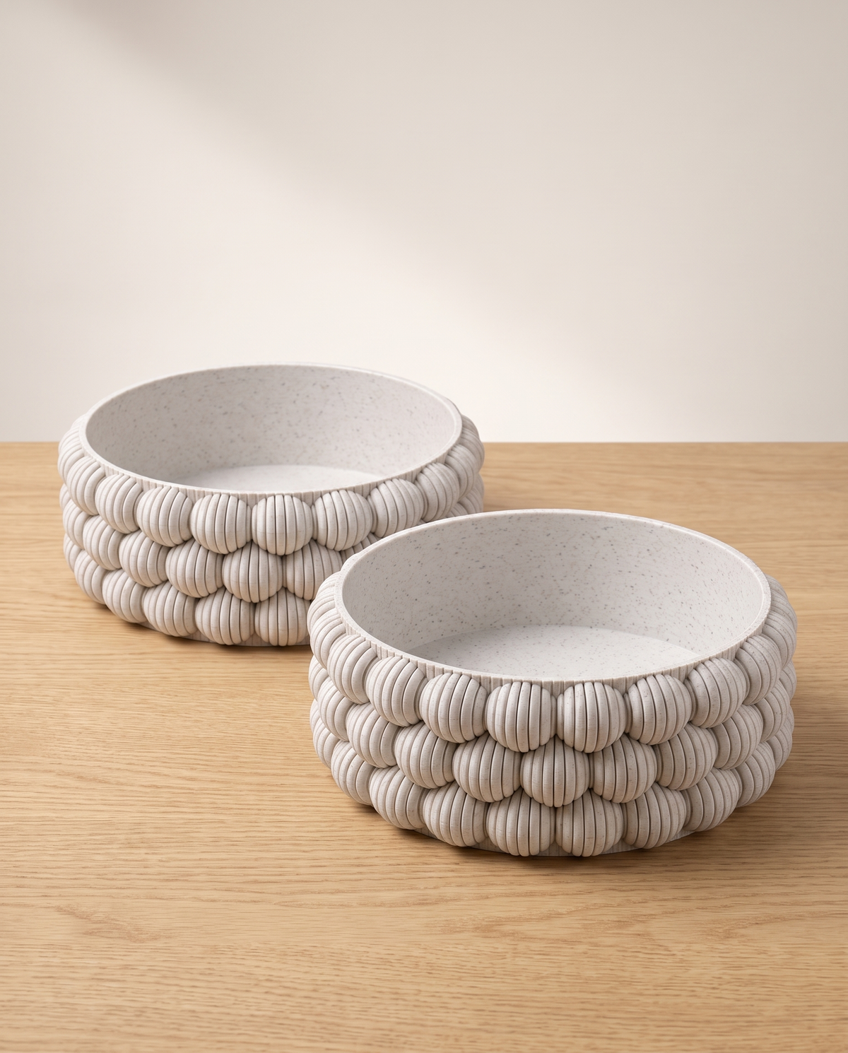 Bubble Bowl Pair: two DiyArts 3D printed Bubble Catch-All Bowls in White Marble, wide low ribbed bowls side by side on a light oak surface, studio shot