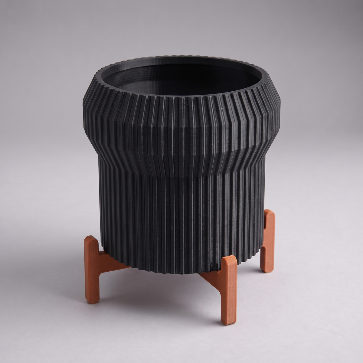 DiyArts Flared Fluted Planter with Stand in Matte Black with burnt rust cross stand, 5 inch ribbed plant pot, studio product shot