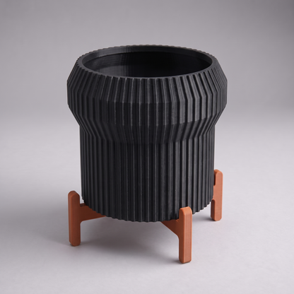 DiyArts Flared Fluted Planter with Stand in Matte Black with burnt rust cross stand, 5 inch ribbed plant pot, studio product shot