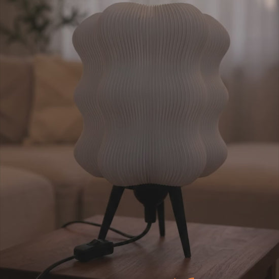 Wave Table Lamp turning on, glowing warmly in a living room