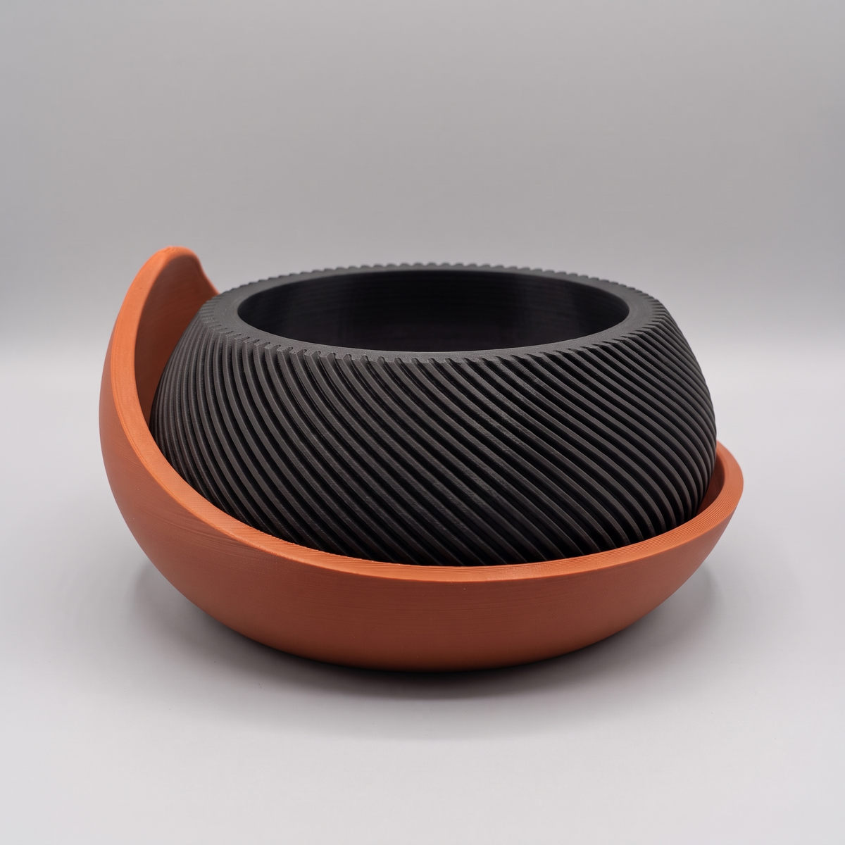 Swirl Ribbed Bowl Planter with Cradle Saucer in Matte Black with a Burnt Rust saucer, studio view
