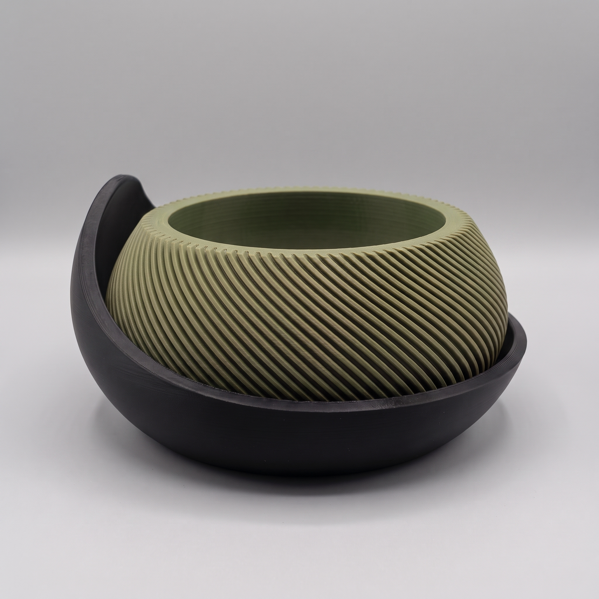 Swirl Ribbed Bowl Planter with Cradle Saucer in Moss Green with a Matte Black saucer, studio view