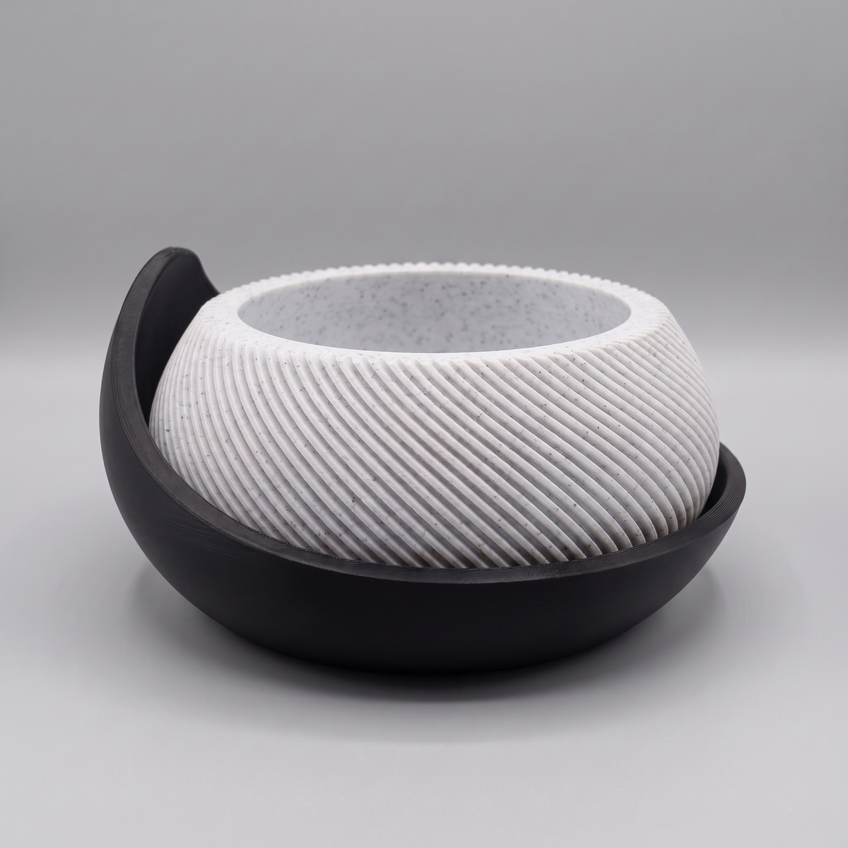 Swirl Ribbed Bowl Planter with Cradle Saucer in White Marble with a Matte Black saucer, studio view